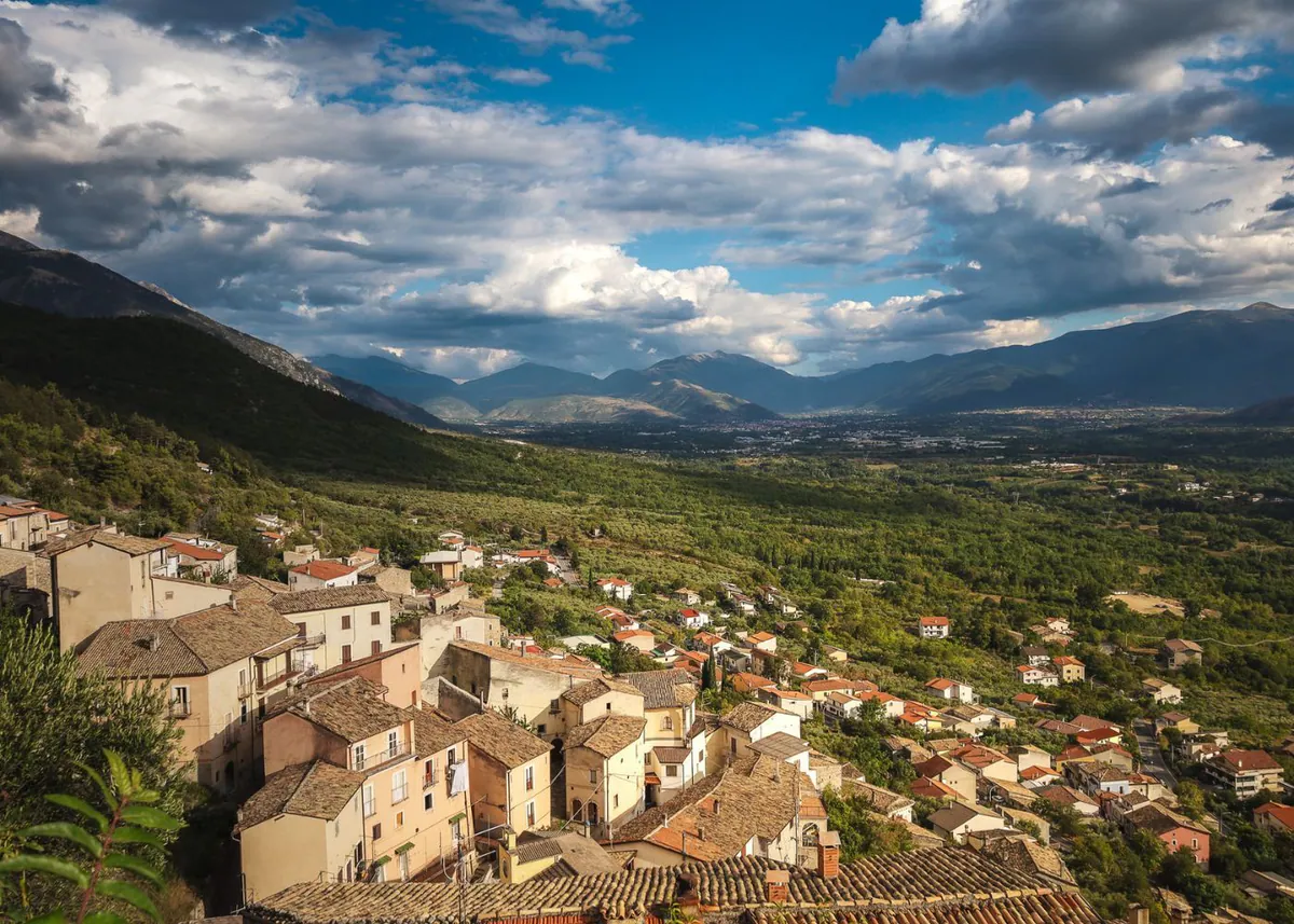 Blick über die Dächer eines Bergdorfs ins Valle Peligna