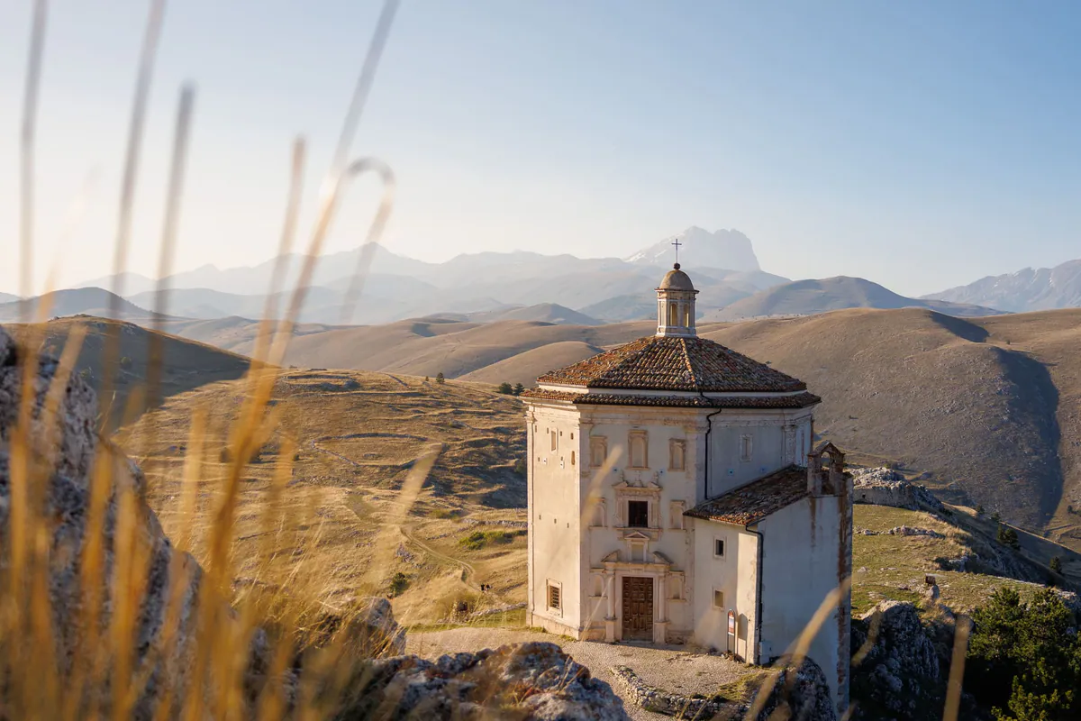 Die Kirche Santa Maria della Pietà auf dem Hügel bei Calascio, dahinter die Gipfel des Gran Sasso