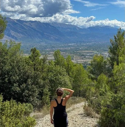 Wanderin auf einem Pfad mit Blick ins Tal