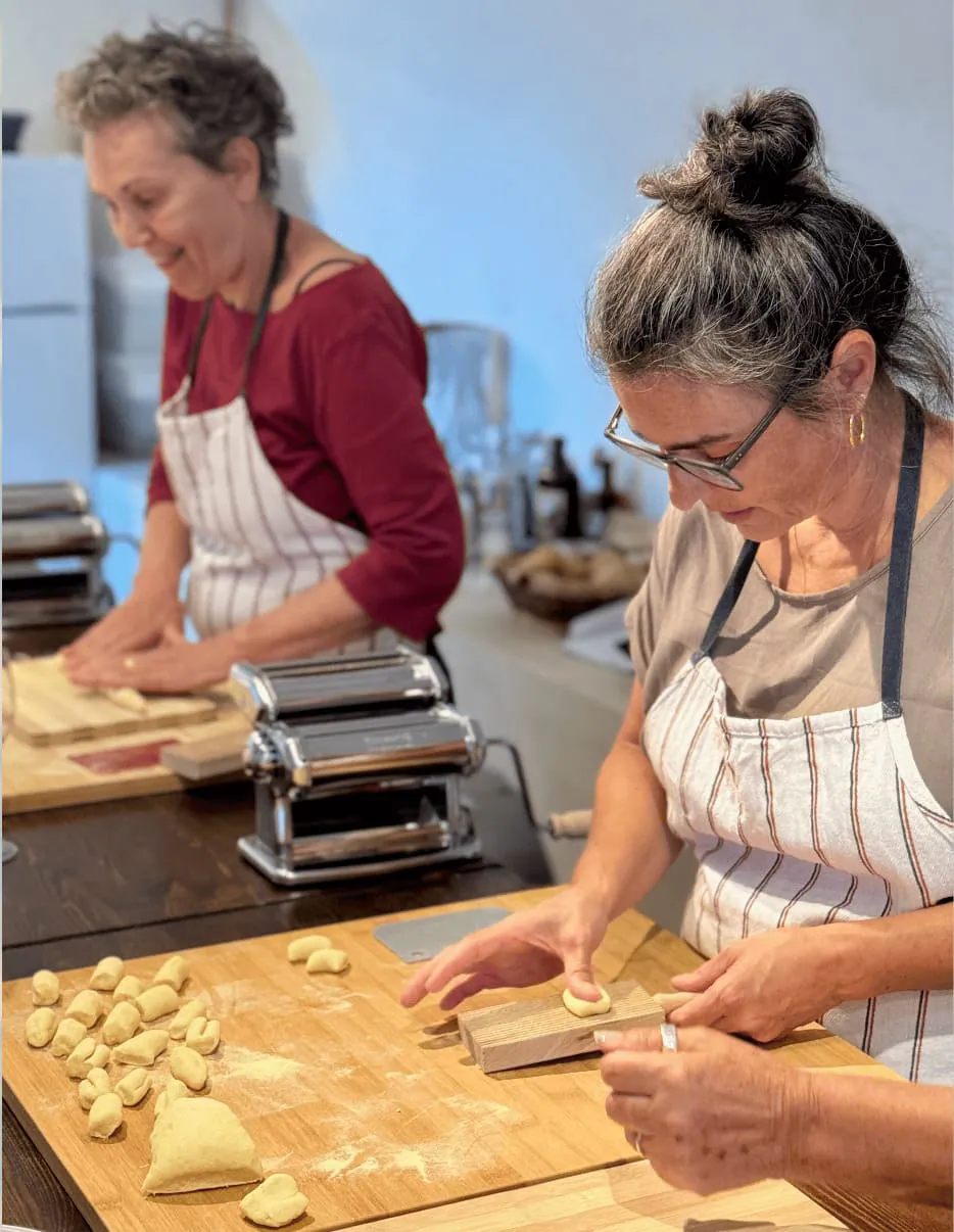 Zwei Frauen formen beim Kochkurs im Kochstudio des casa abruzzo Pasta von Hand