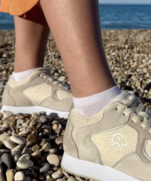 Zita in den Giesswein Retro Runner aus Wolle am Kiesstrand
